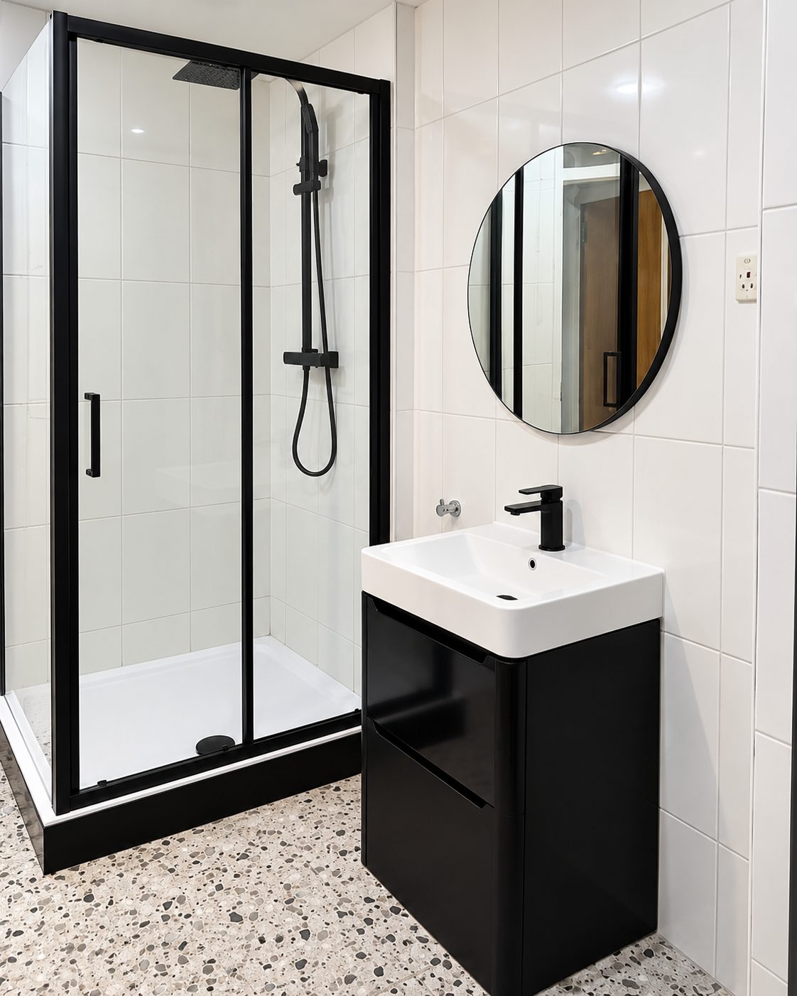 Black-framed shower, vanity and terrazzo floor
